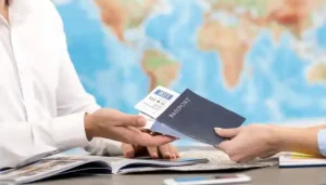 Findanyagent visa consultant handing a passport and flight tickets to a client for Dubai visit visa planning.
